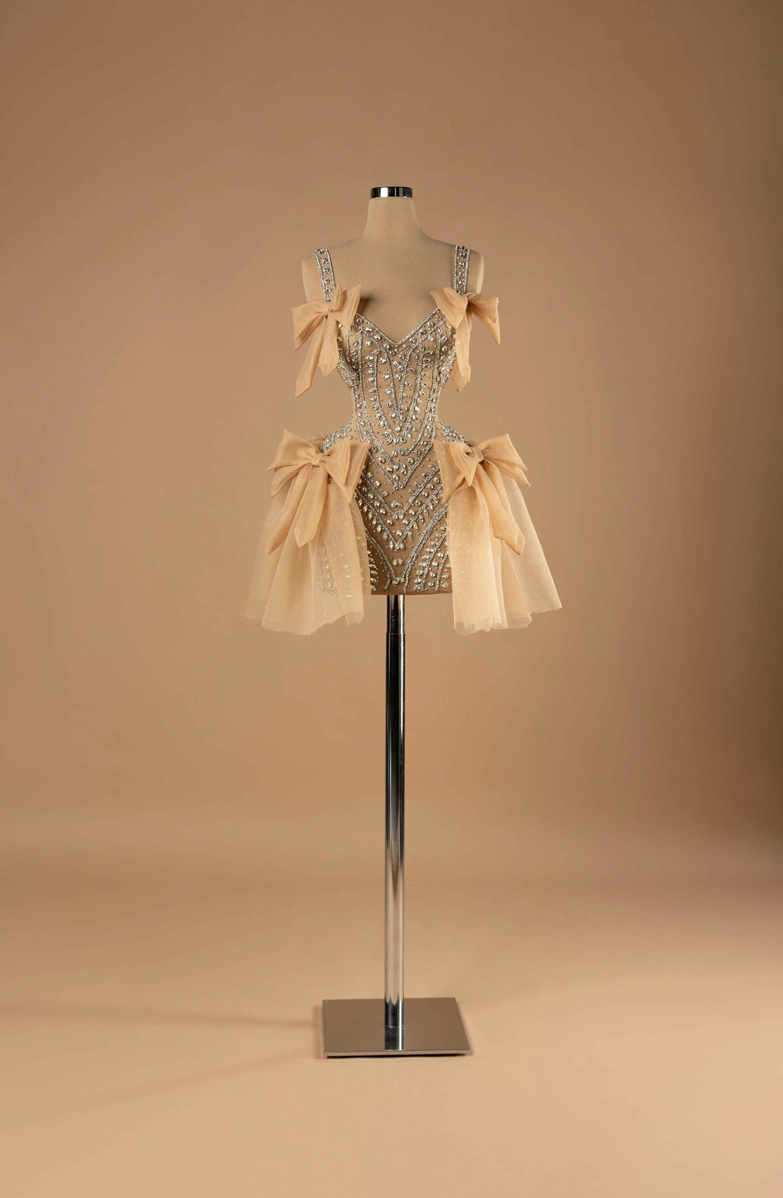 Sihëna Obsidian Allure — champagne sweetheart mini cocktail dress with crystal-beaded corset bodice on illusion tulle and champagne organza bows.