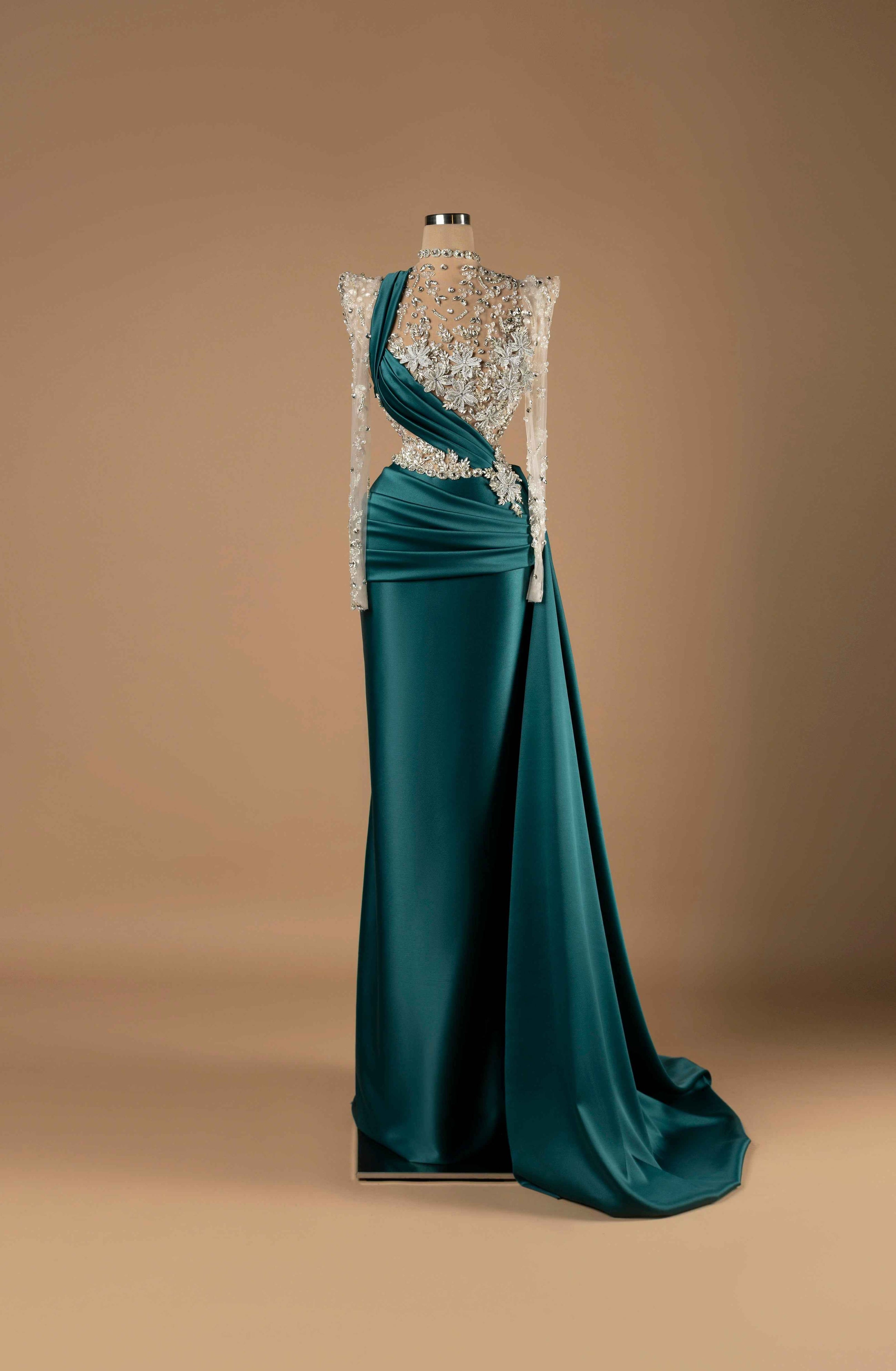 Sihëna Emerald Enchantment — emerald high-neck long-sleeve column gown with silver crystal-floral beadwork on illusion bodice and draped teal satin overskirt train.