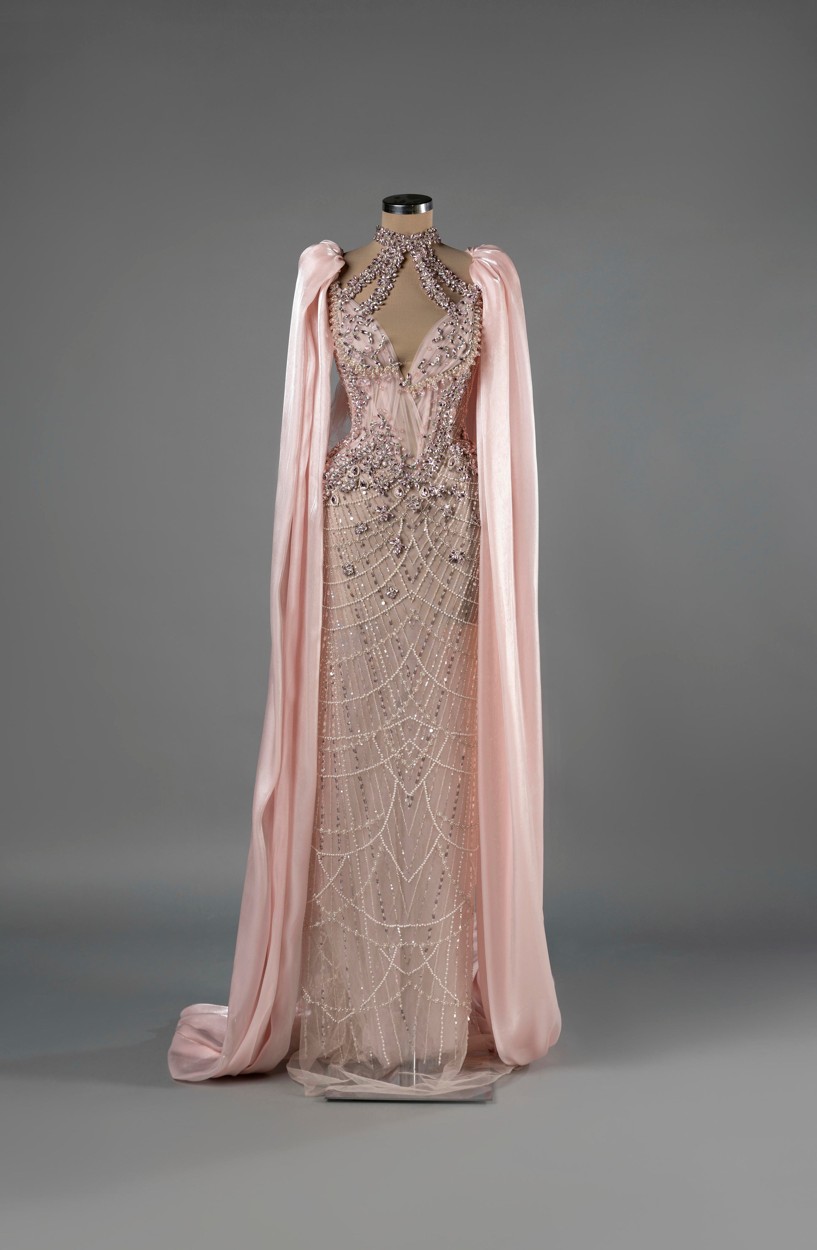 Sihëna Celestial Bloom — blush halter column gown with a deep keyhole, crystal-pearl beadwork on net and a chiffon cape.