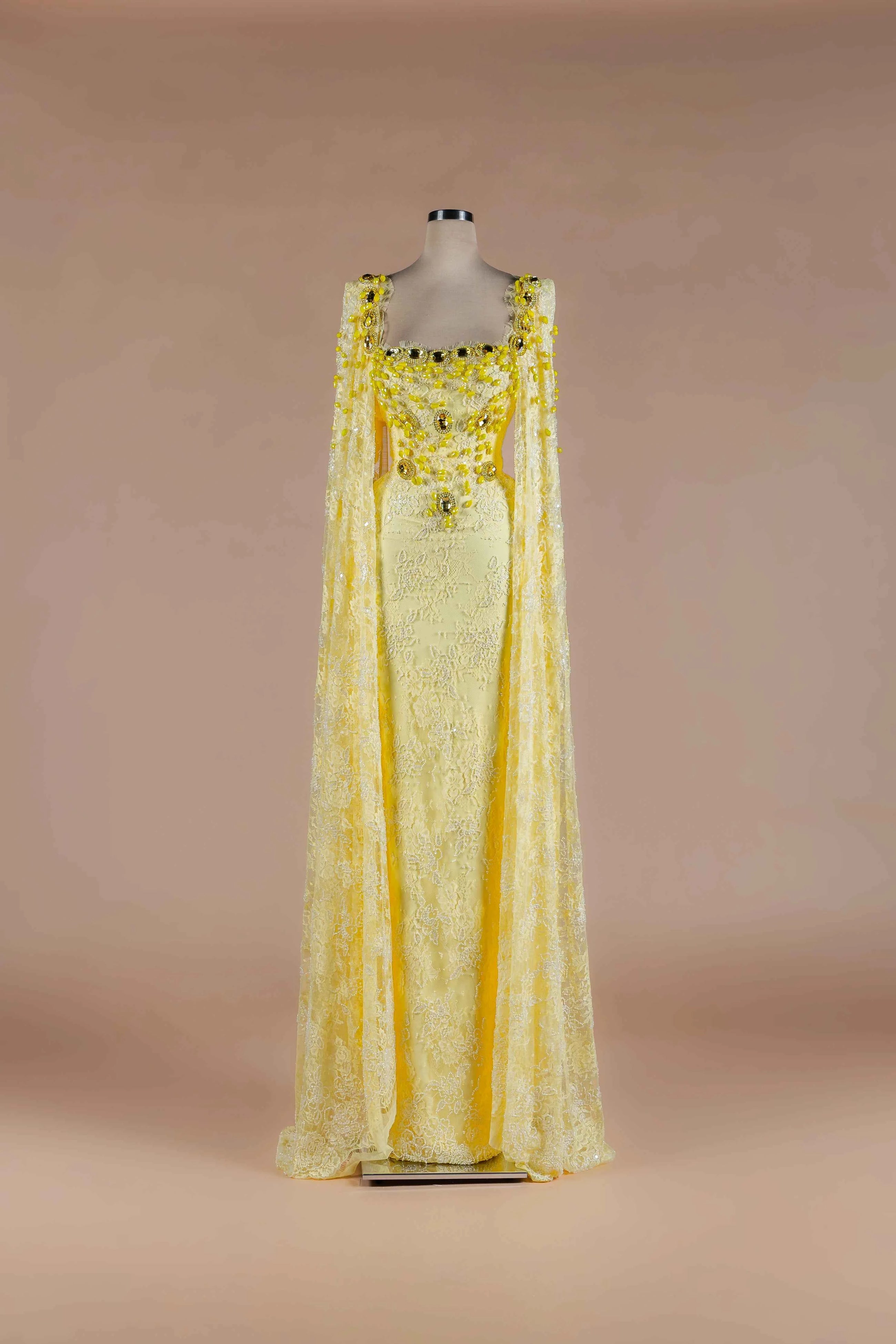 Sihëna Citrine Heirloom — marigold square-neckline lace column gown with crystal-and-bead floral stones and lace cape panels.