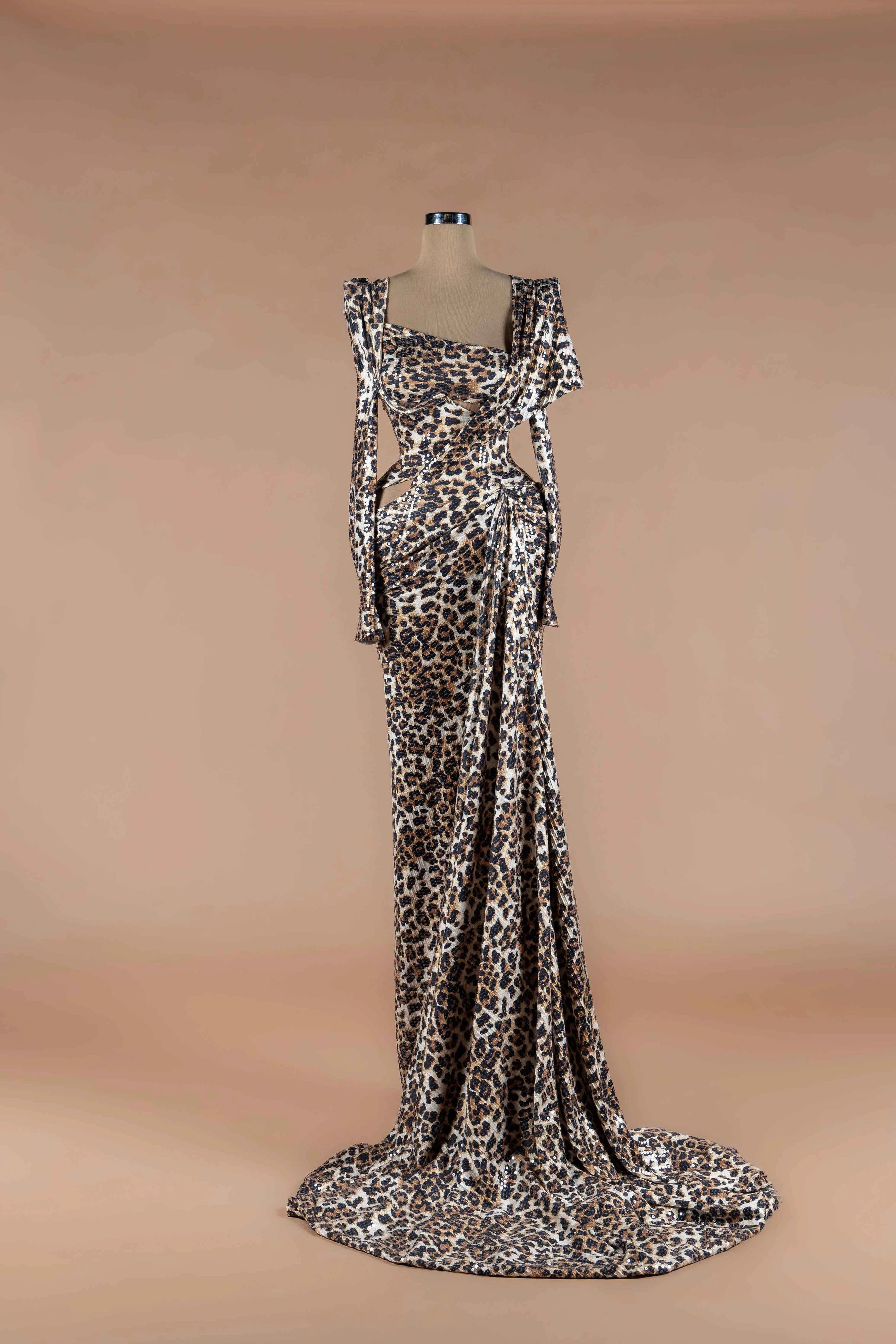 Sihëna Savanna Prowl — leopard-print sequin asymmetric long-sleeve mermaid gown with structured shoulder, draped waist and train.