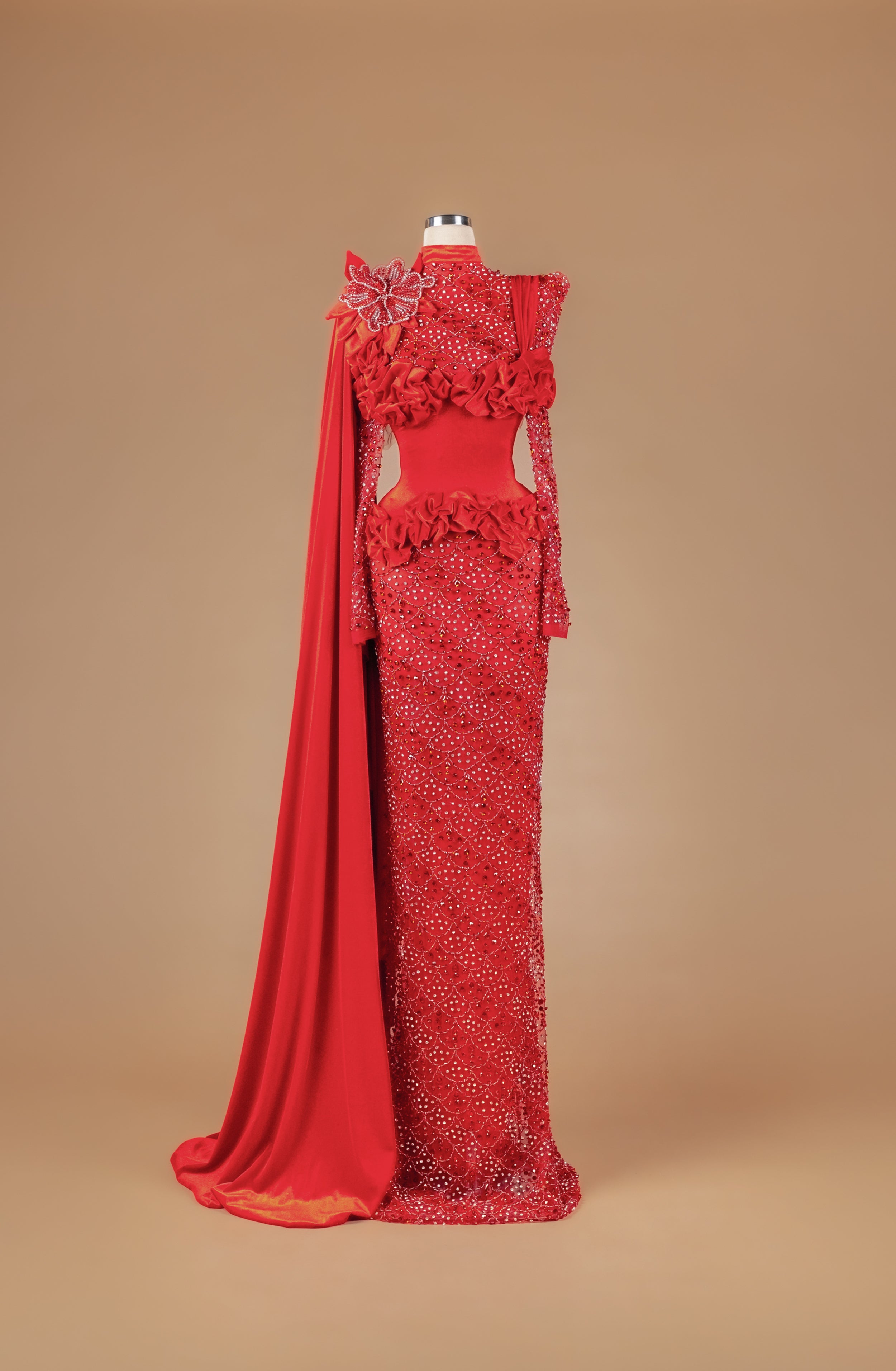 Sihëna Pomegranate Court Bloom — red high-neck long-sleeve column gown with crystal beadwork, 3D floral appliqué, ruffles and draped cape train.