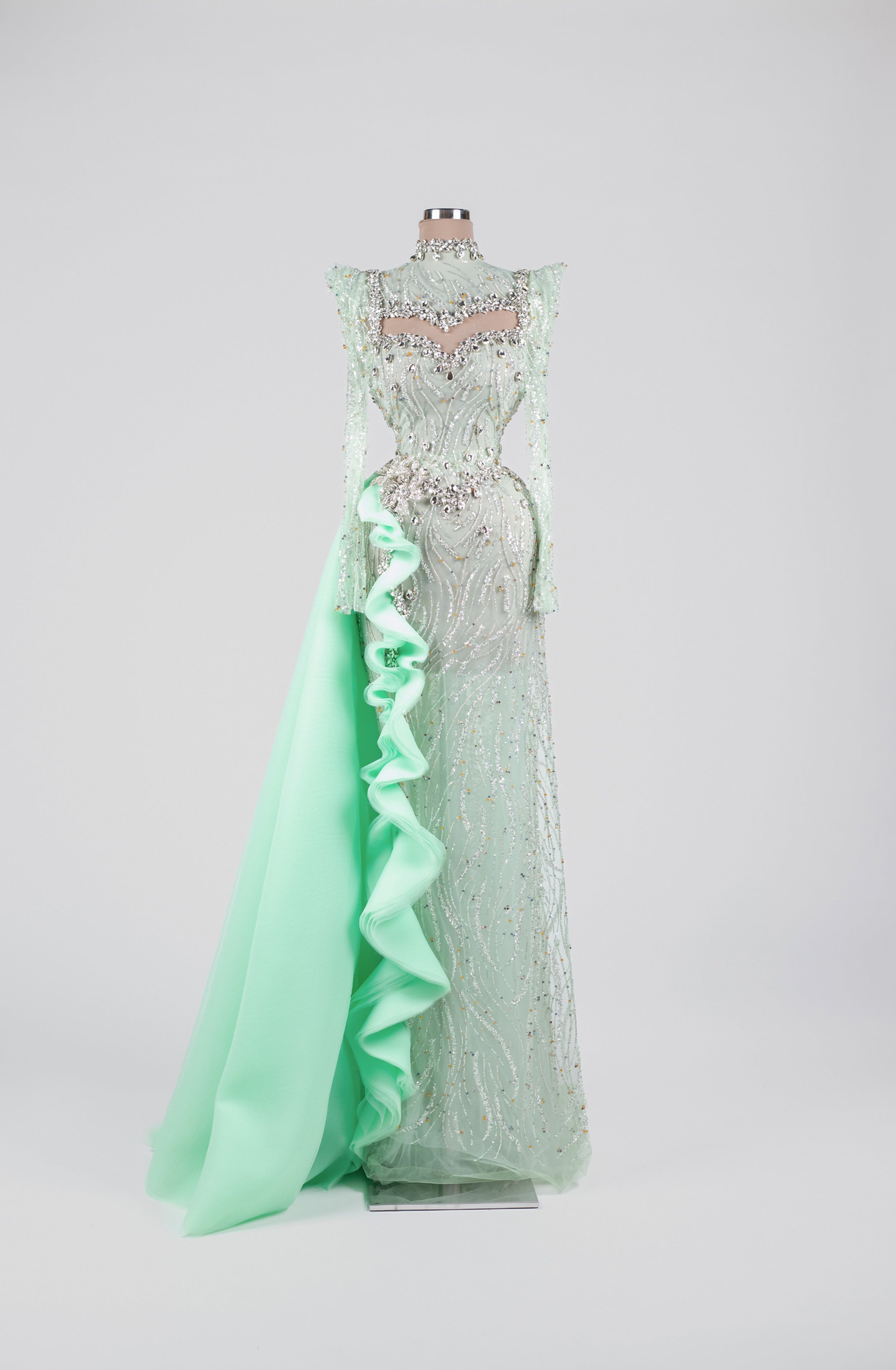 Sihëna Celadon Aurora Crest — mint high-neck long-sleeve gown with crystal-sequin beadwork on sheer tulle and an organza ruffle overskirt.