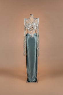 Sihëna Silver Lotus — sage-green high-neck long-sleeve column gown with silver crystal illusion bodice and satin skirt.