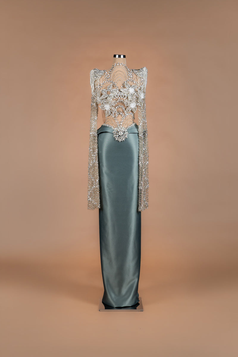 Sihëna Silver Lotus — sage-green high-neck long-sleeve column gown with silver crystal illusion bodice and satin skirt.