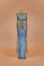 Sihëna Oasis Baroque — powder-blue high-neck long-sleeve sheer gown with gold and blue crystal baroque beadwork.