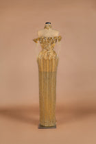 Sihëna Golden Cascade — gold off-shoulder column gown with crystal floral bodice and cascading beaded fringe skirt.