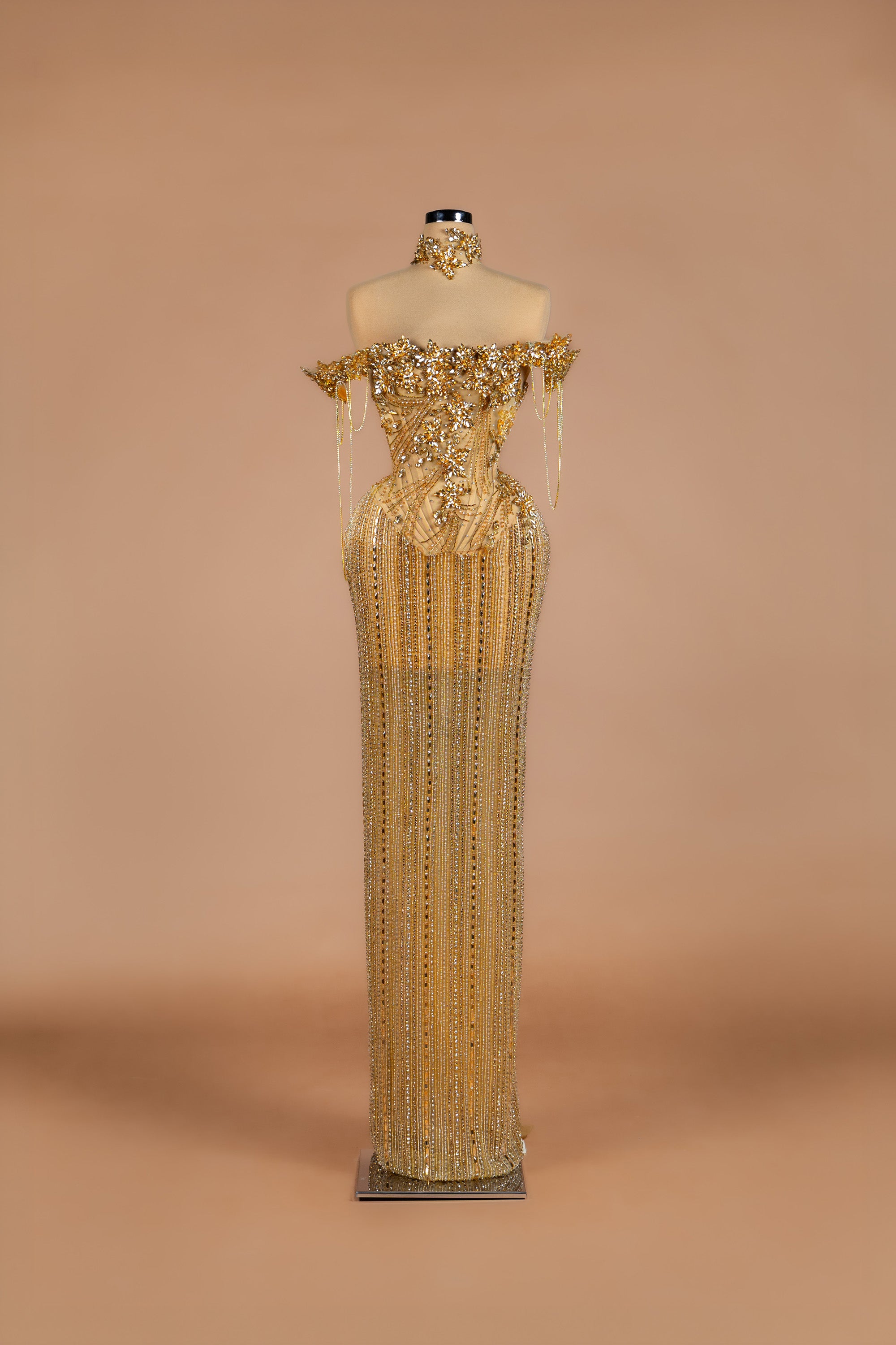 Sihëna Golden Cascade — gold off-shoulder column gown with crystal floral bodice and cascading beaded fringe skirt.