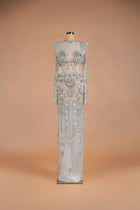 Sihëna Venetian Crystal — silver high-neck long-sleeve column gown with crystal floral beadwork on sheer nude illusion base.