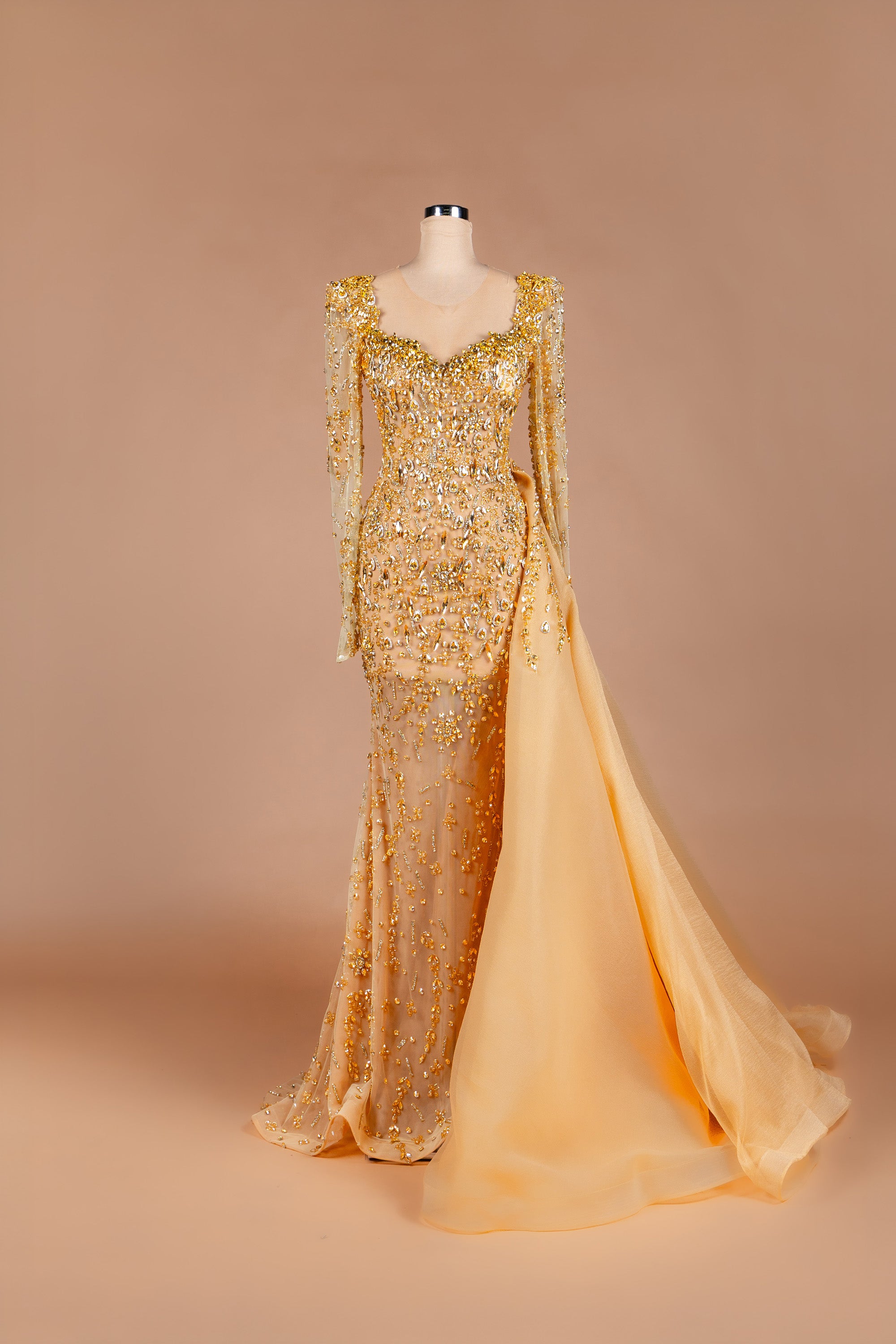 Sihëna Honey Reverie — gold sweetheart long-sleeve crystal-beaded illusion gown with sheer organza overskirt and train.