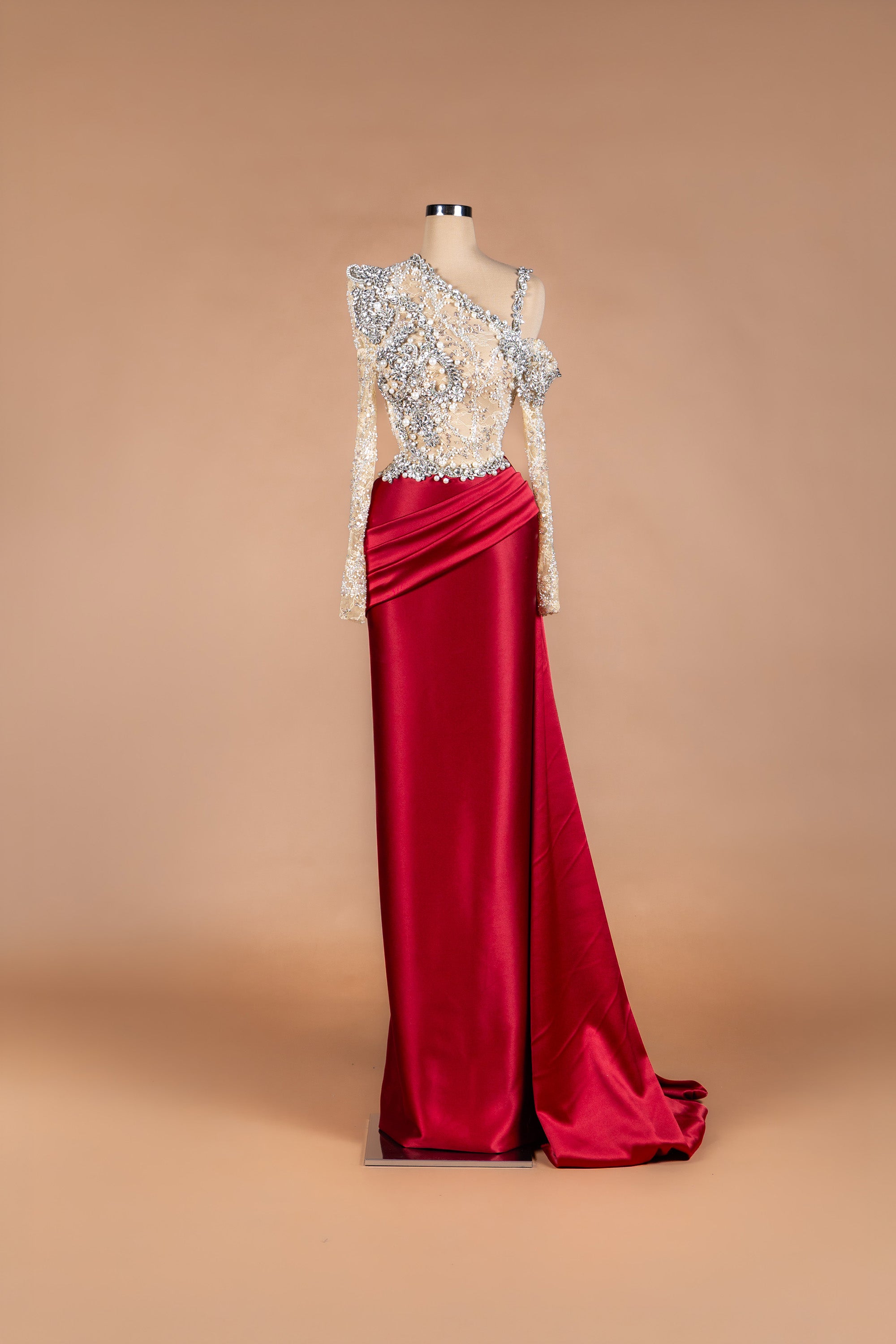 Sihëna Crimson Courtesan — crimson one-shoulder gown with crystal-and-pearl lace illusion bodice and draped satin mermaid skirt.