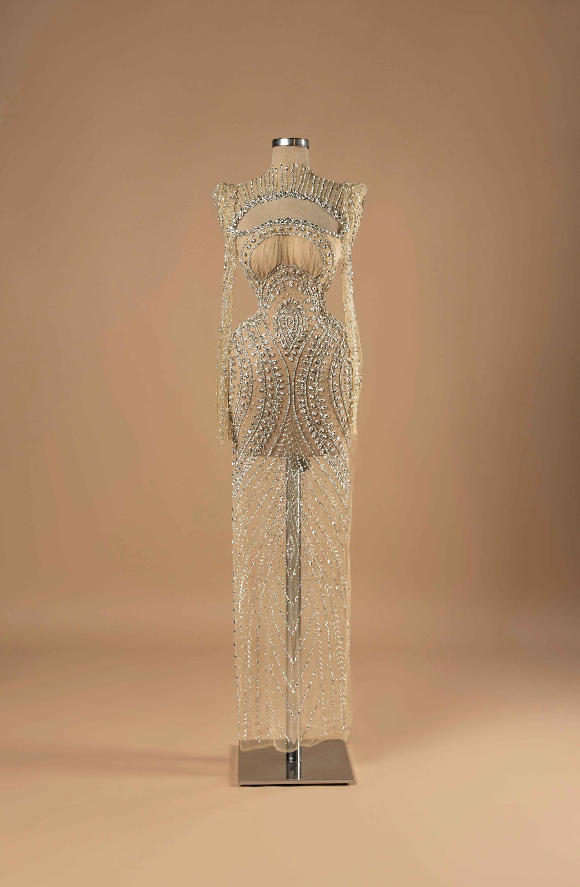 Sihëna Starlit Symphony — nude high-neck long-sleeve column evening gown in sheer crystal-beaded illusion tulle with an open chest cutout.
