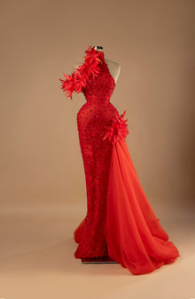 Sihëna Scarlet Inferno — red one-shoulder sleeveless mermaid evening gown with red feather floral appliqués, crystal beading and organza overskirt train.