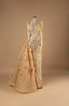 Sihëna Golden Blossom Cascade — champagne high-neck long-sleeve column evening gown with silver crystal beadwork, 3D organza florals and cascading overskirt train.