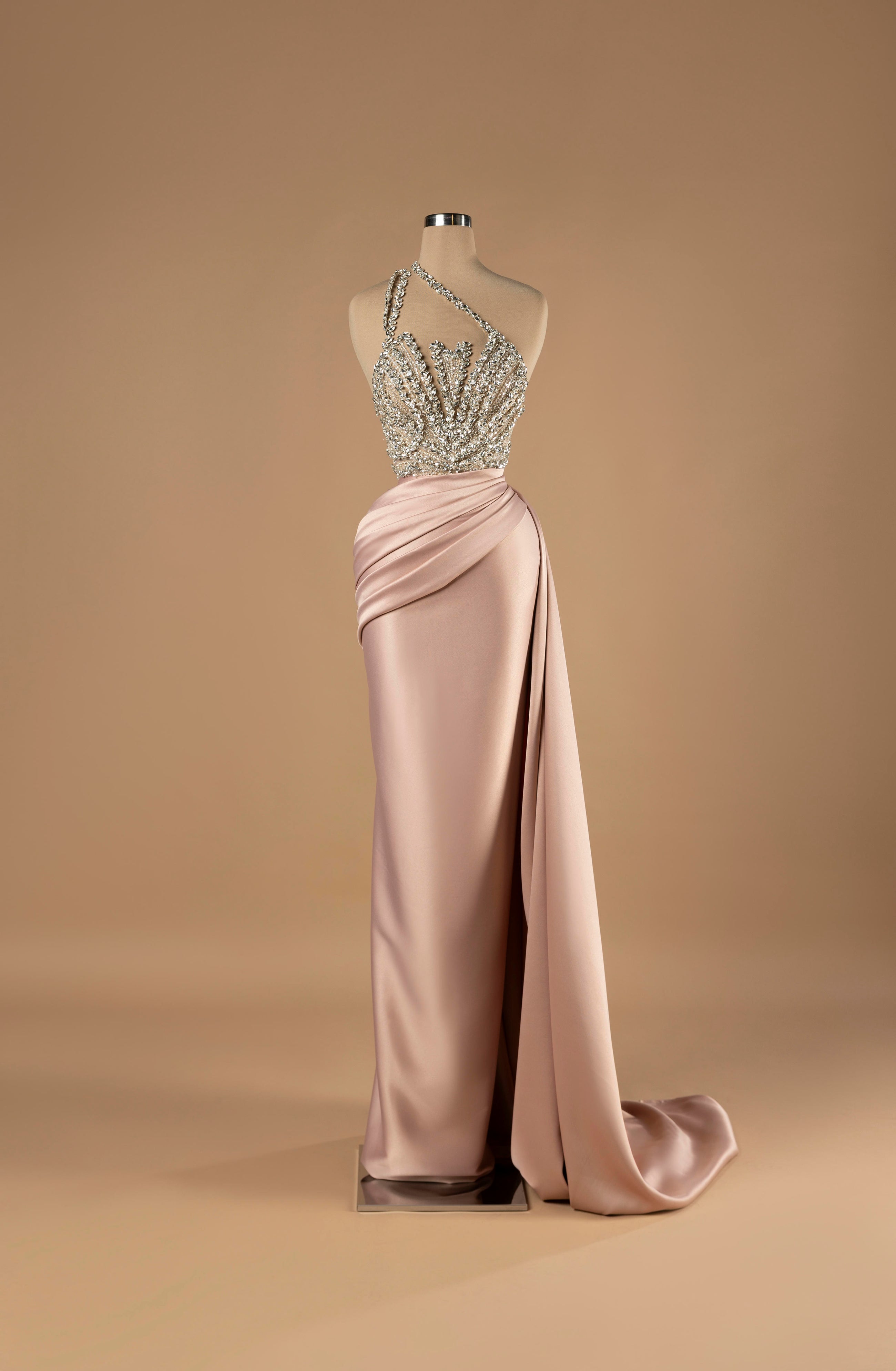 Sihëna Blush Radiance — blush one-shoulder column gown with a crystal-beaded sheer bodice and draped satin skirt with slit.