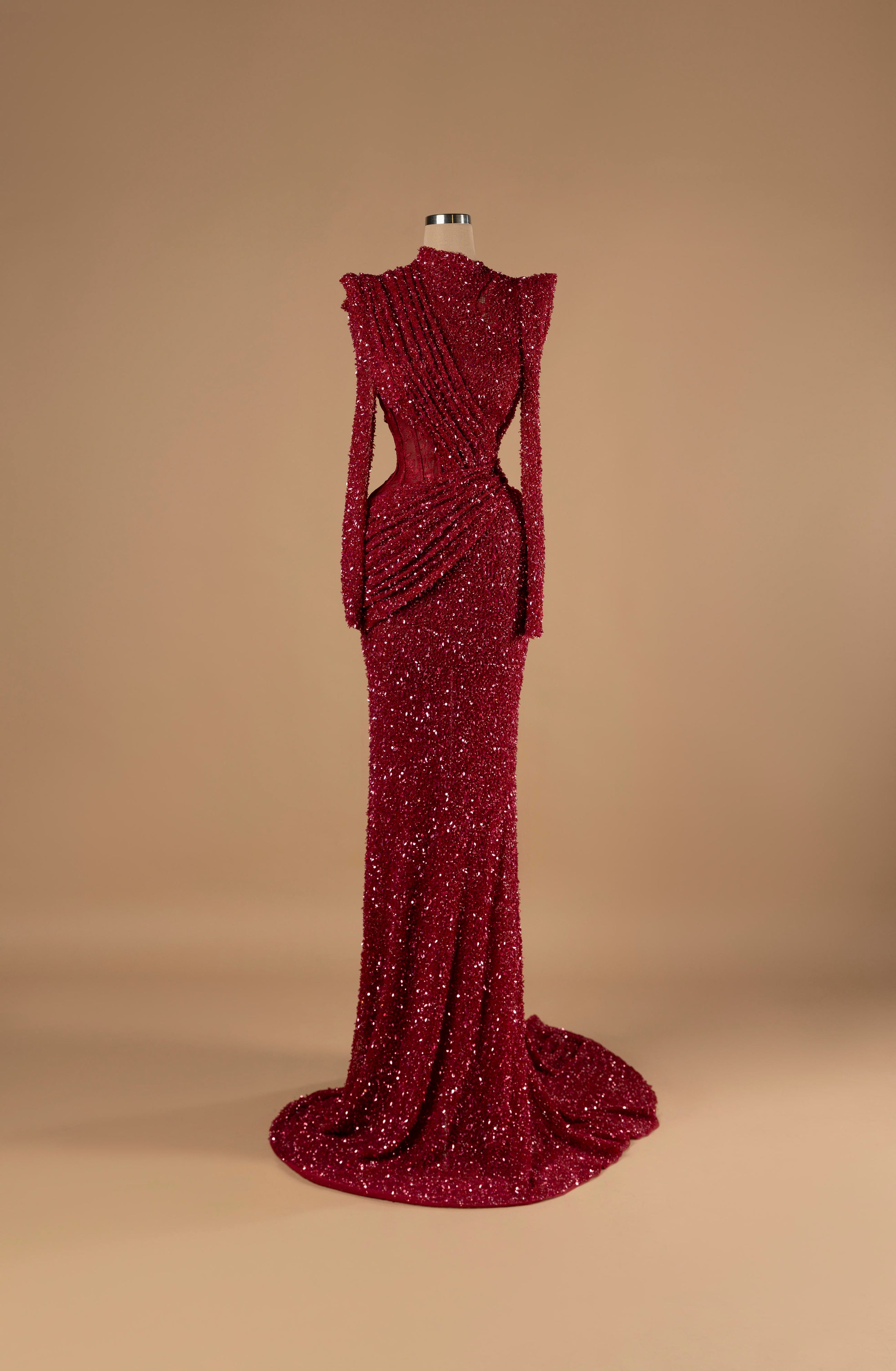 Sihëna Crimson Eclipse — burgundy high-neck long-sleeve sequin mermaid gown with ruched draping, a side cutout and a train.