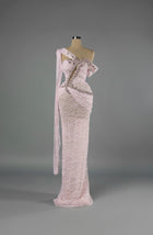 Sihëna Petal Rapture — blush one-shoulder column gown in beaded lace with pink crystal and pearl beadwork over a sheer base.
