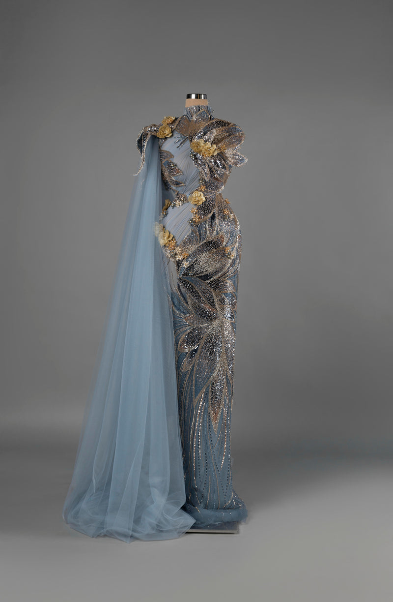 Sihëna Eclipse Reverie — dusty-blue high-neck sleeveless column gown with silver-gold sequin floral motifs and a tulle cape.