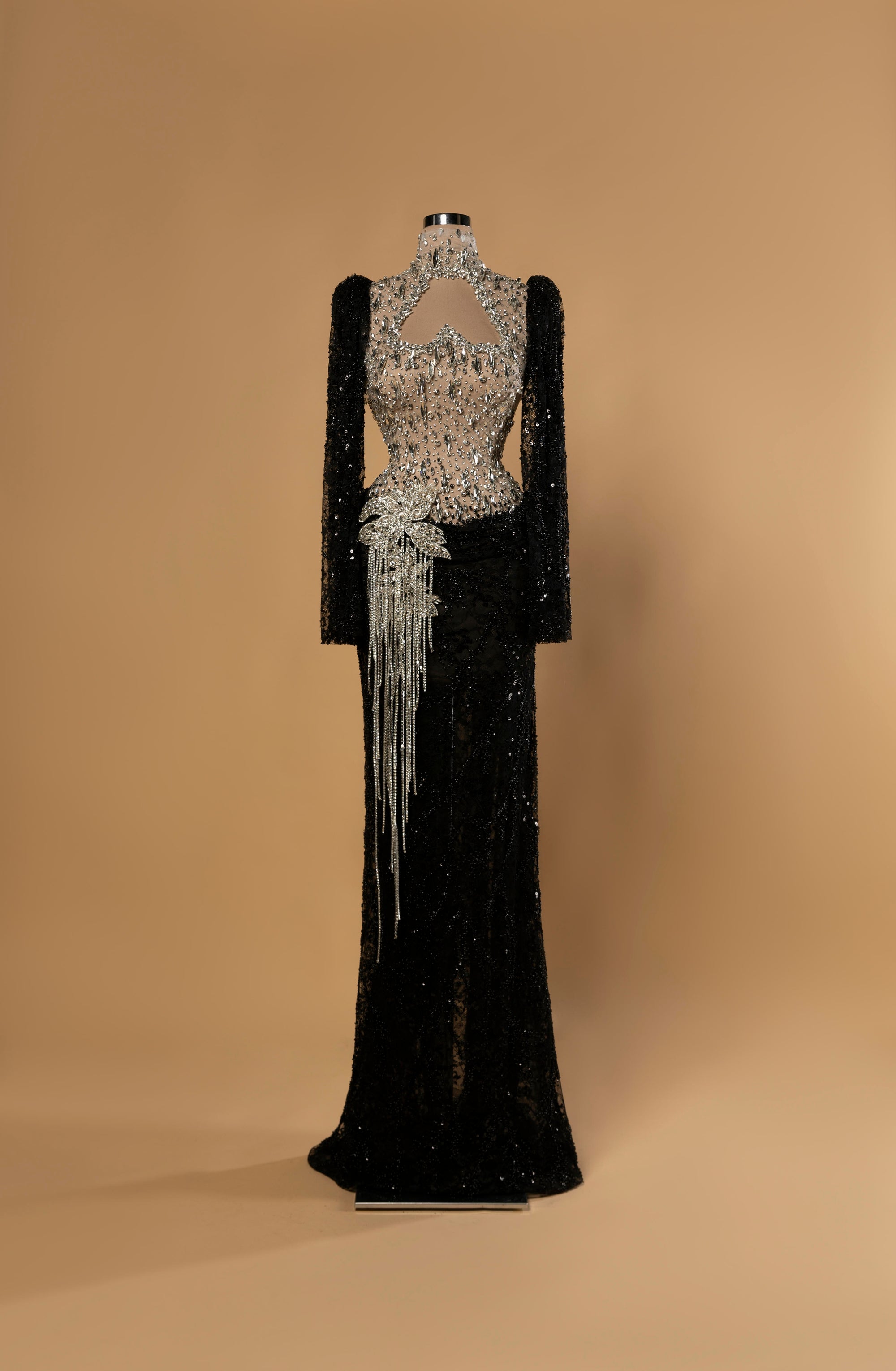 Sihëna Obsidian Glimmer — black high-neck long-sleeve column gown with silver crystal illusion bodice, black sequin skirt and crystal fringe.