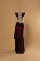 Sihëna Garnet Allure — burgundy high-neck long-sleeve column gown with crystal illusion bodice and draped satin wrap skirt.