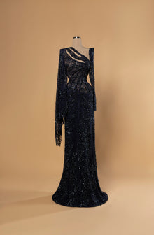 Sihëna Nightfall Arabesque — navy one-shoulder long-sleeve mermaid gown in beaded sequin lace with slashed chest cutouts.