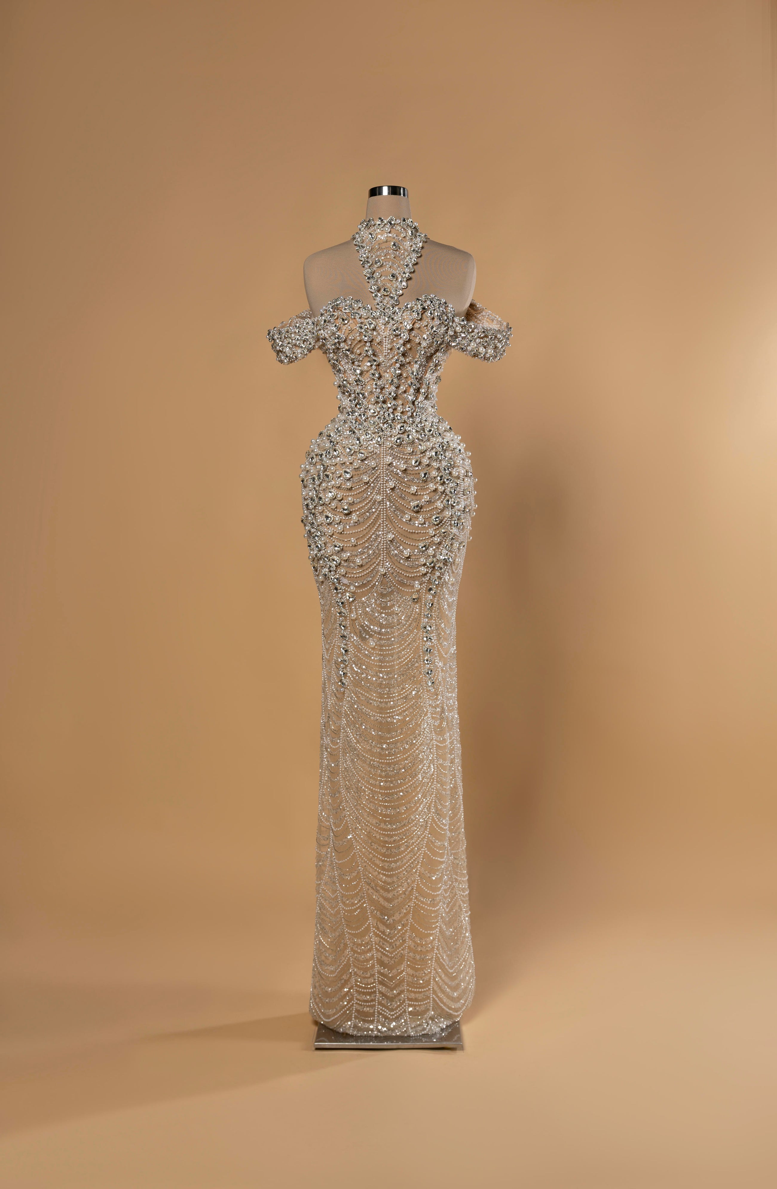 Sihëna Radiant Tapestry — silver high-neck halter off-shoulder mermaid gown with crystal and pearl beadwork and draped pearl swags.