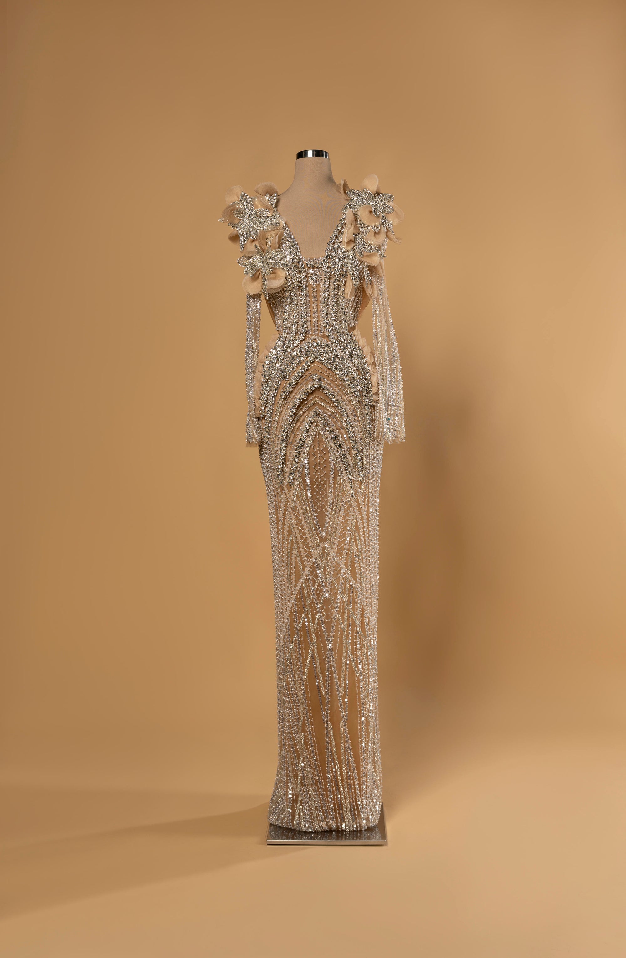 Sihëna Opaline Arches — nude deep-v long-sleeve column gown with arched crystal and pearl beadwork and 3D floral beaded shoulders.