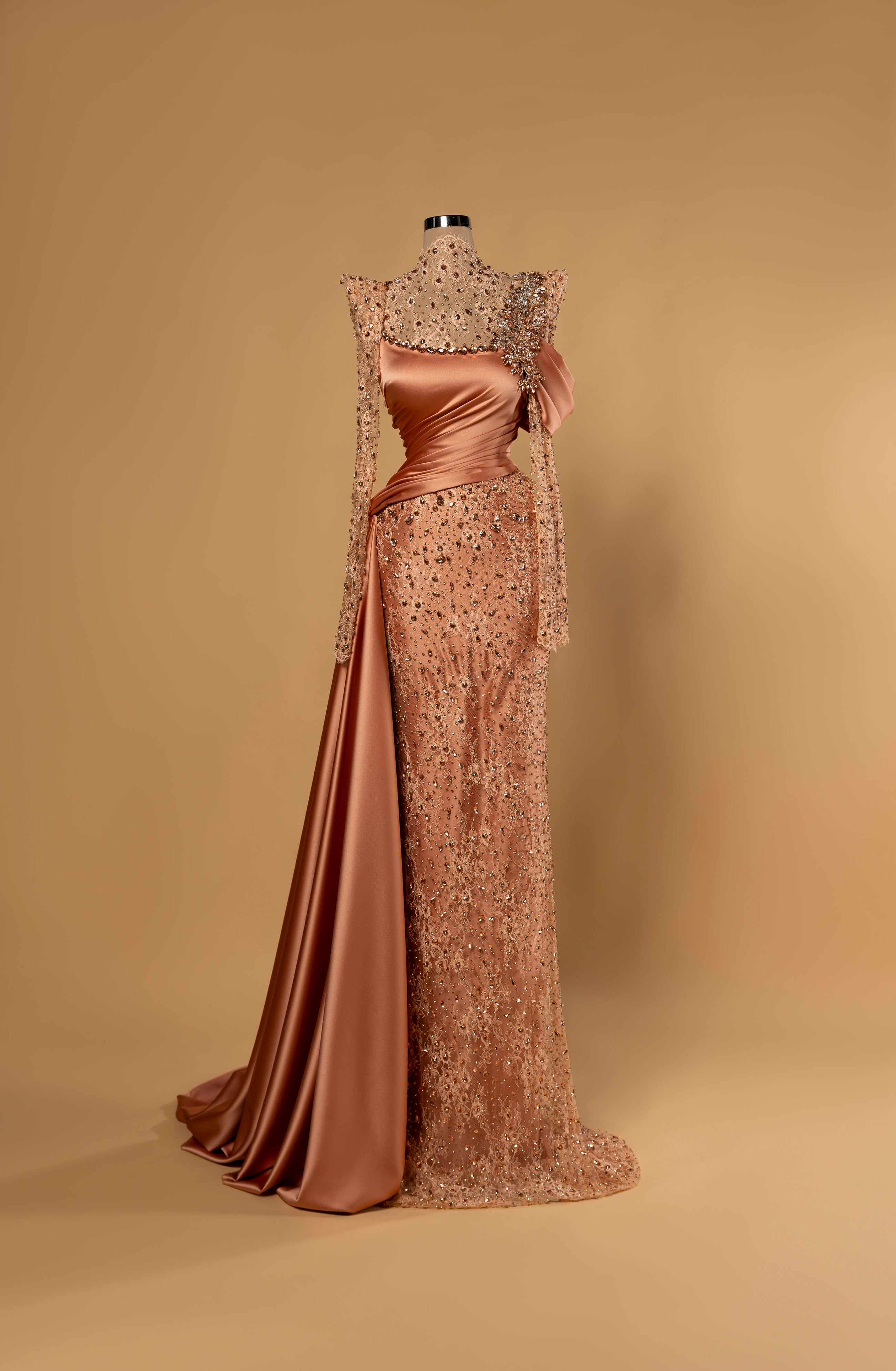 Sihëna Amber Monarch — amber high-neck long-sleeve column evening gown in satin with crystal illusion yoke, draped bodice and overskirt.