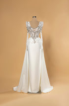 Sihëna Celestine Crest — ivory v-neck long-sleeve a-line bridal gown in satin with pearl-crystal illusion bodice and overskirt train.