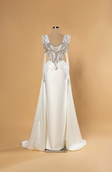 Sihëna Celestine Crest — ivory v-neck long-sleeve a-line bridal gown in satin with pearl-crystal illusion bodice and overskirt train.