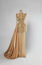 Sihëna Desert Marquise — champagne high-neck long-sleeve column evening gown in beaded tulle illusion with gold satin side overskirt.