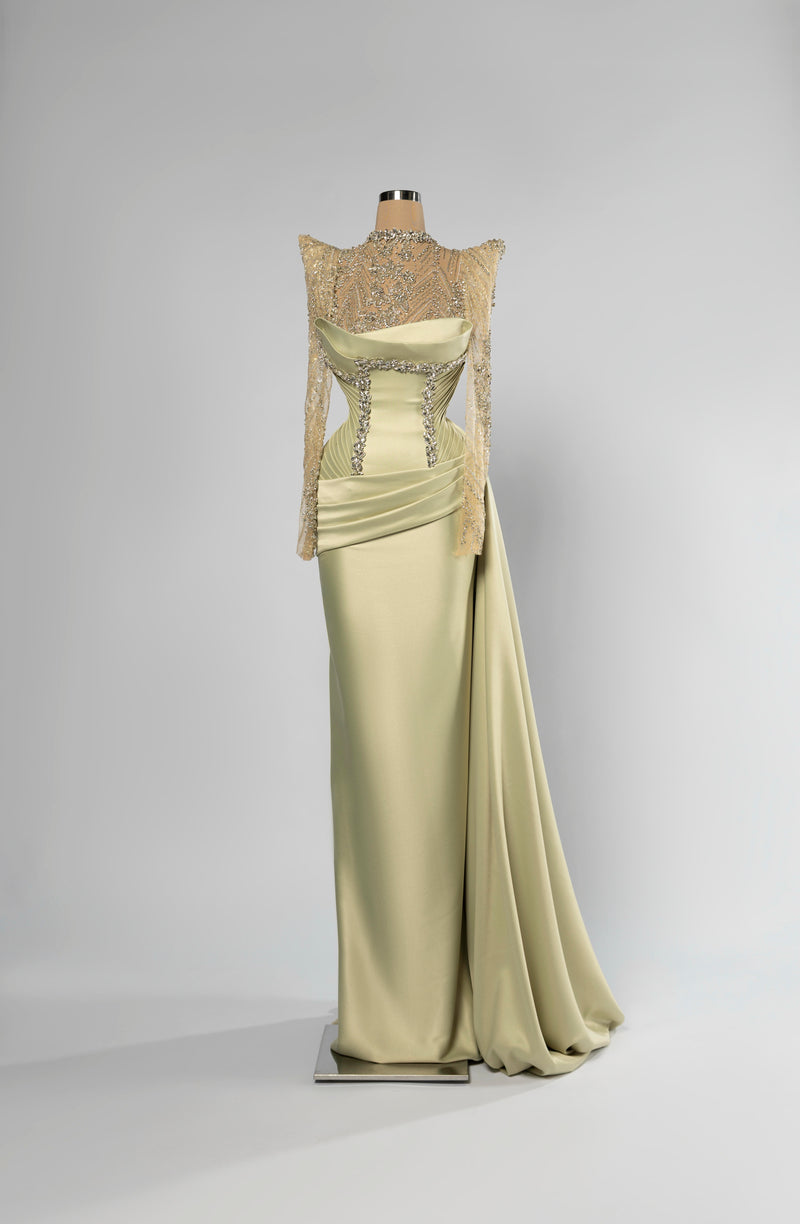 Sihëna Pistachio Lumina — pistachio high-neck long-sleeve column evening gown in glossy satin with crystal-beaded illusion bodice and overskirt.