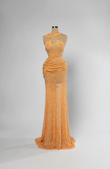 Sihëna Marigold Ripple — marigold asymmetric sleeveless mermaid evening gown in dense sequins with draped skirt and sheer side panel.
