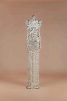 Sihëna Silver Scallop — silver high-neck long-sleeve column gown with scalloped crystal-pearl beadwork on sheer nude tulle.