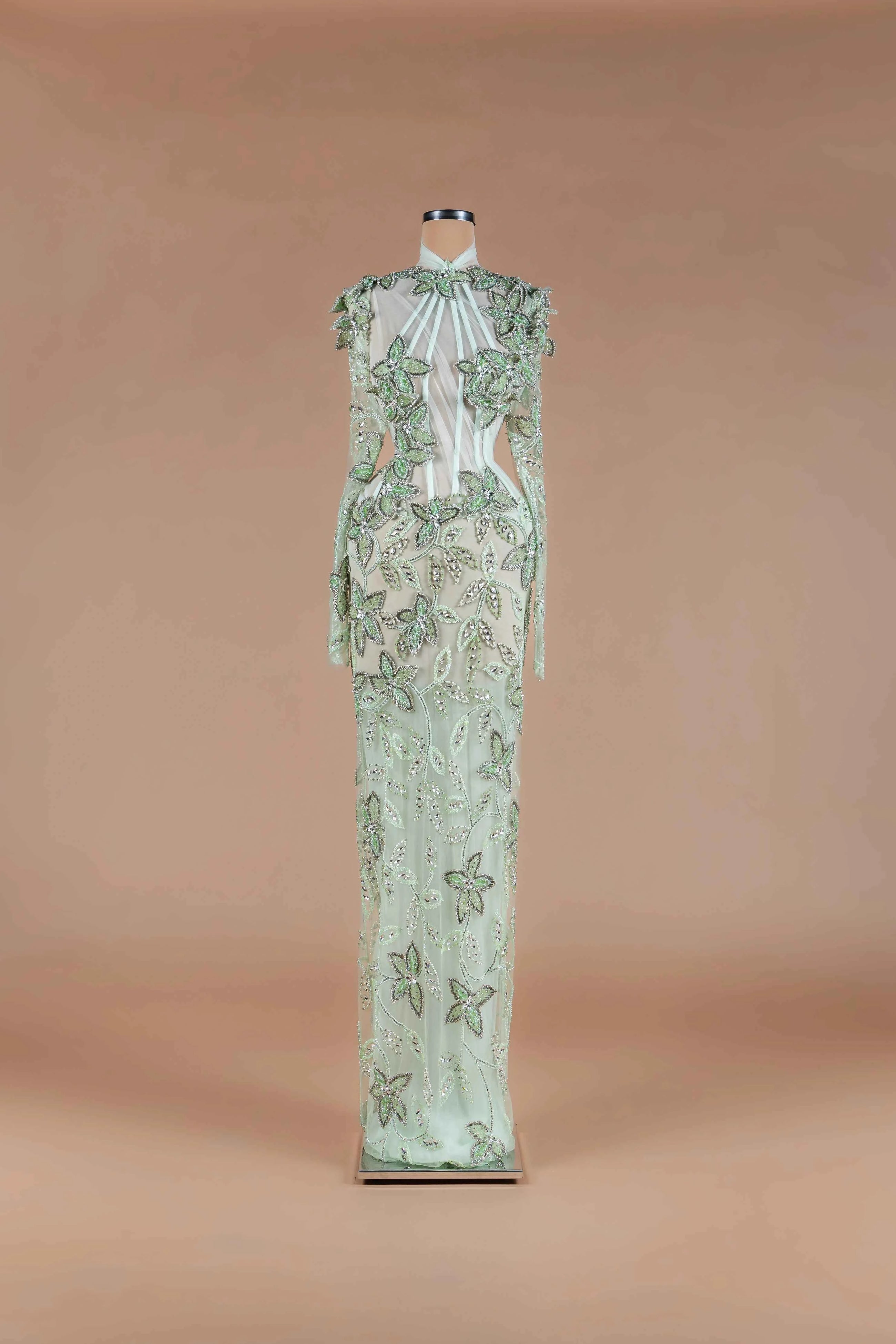 Sihëna Sage Ivy — sage-green high-neck long-sleeve column gown with green floral beadwork on sheer tulle and caped shoulders.