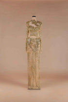 Sihëna Aurelia Sovereign — gold high-neck long-sleeve column gown with crystal and gold beadwork on sheer nude tulle.