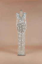 Sihëna Crystalline Garden — silver high-neck long-sleeve column gown with all-over crystal beadwork and 3D white floral appliqué.