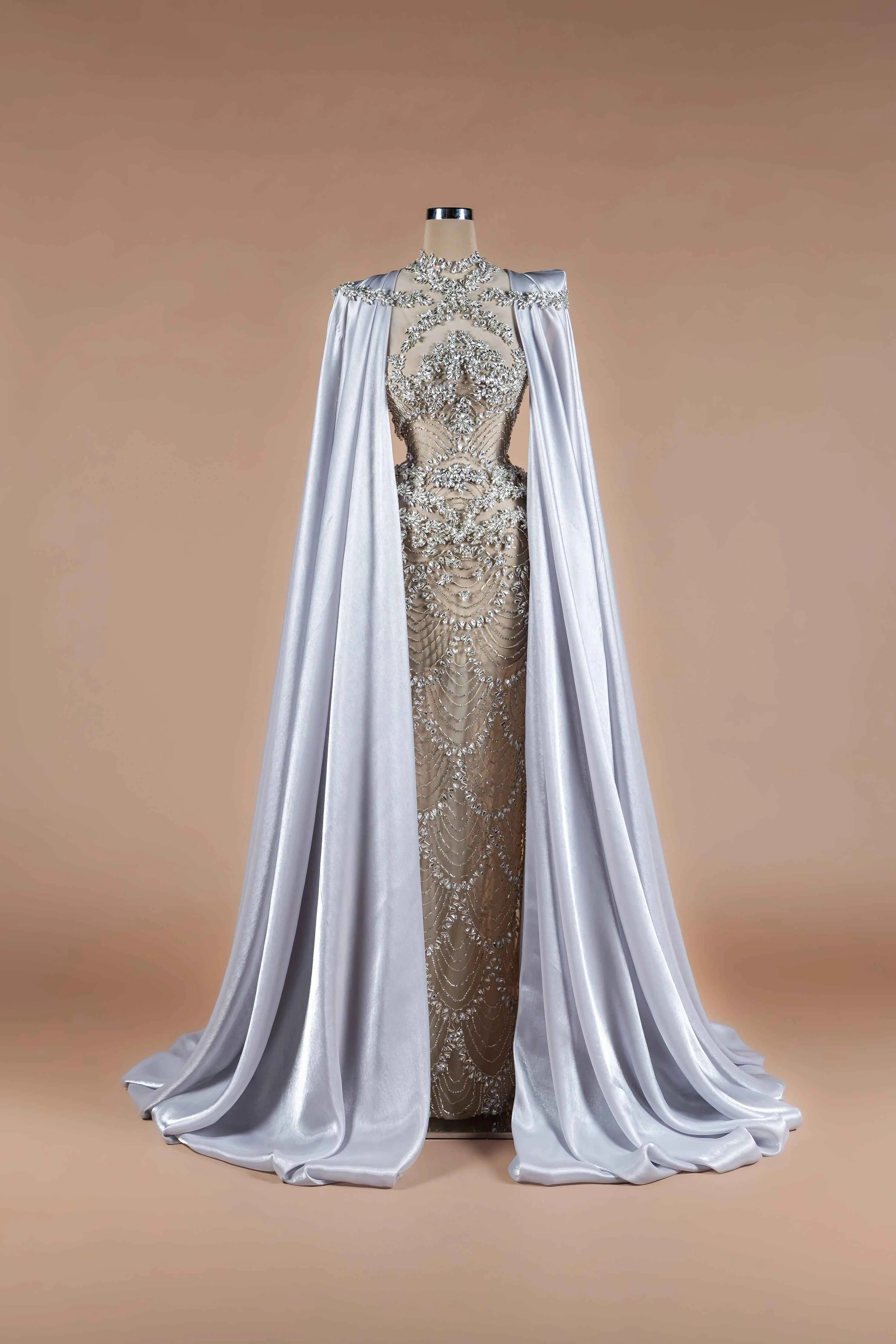 Sihëna Silver Reign — silver high-neck column gown with crystal-beaded sheer bodice and flowing satin cape train.