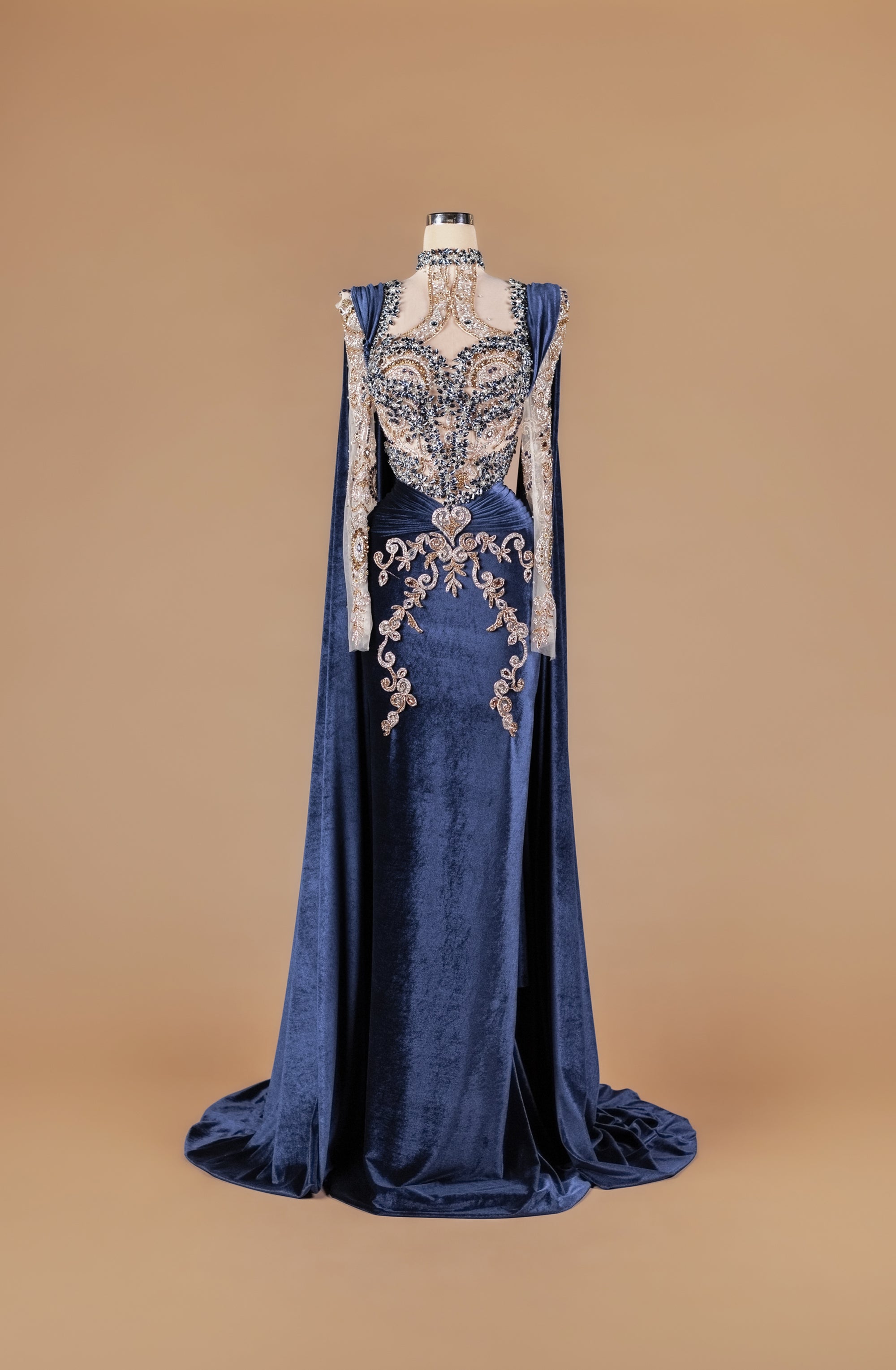 Sihëna Midnight Aureate — navy high-neck long-sleeve velvet mermaid gown with navy and gold crystal beadwork, sheer illusion bodice and cape sleeves.