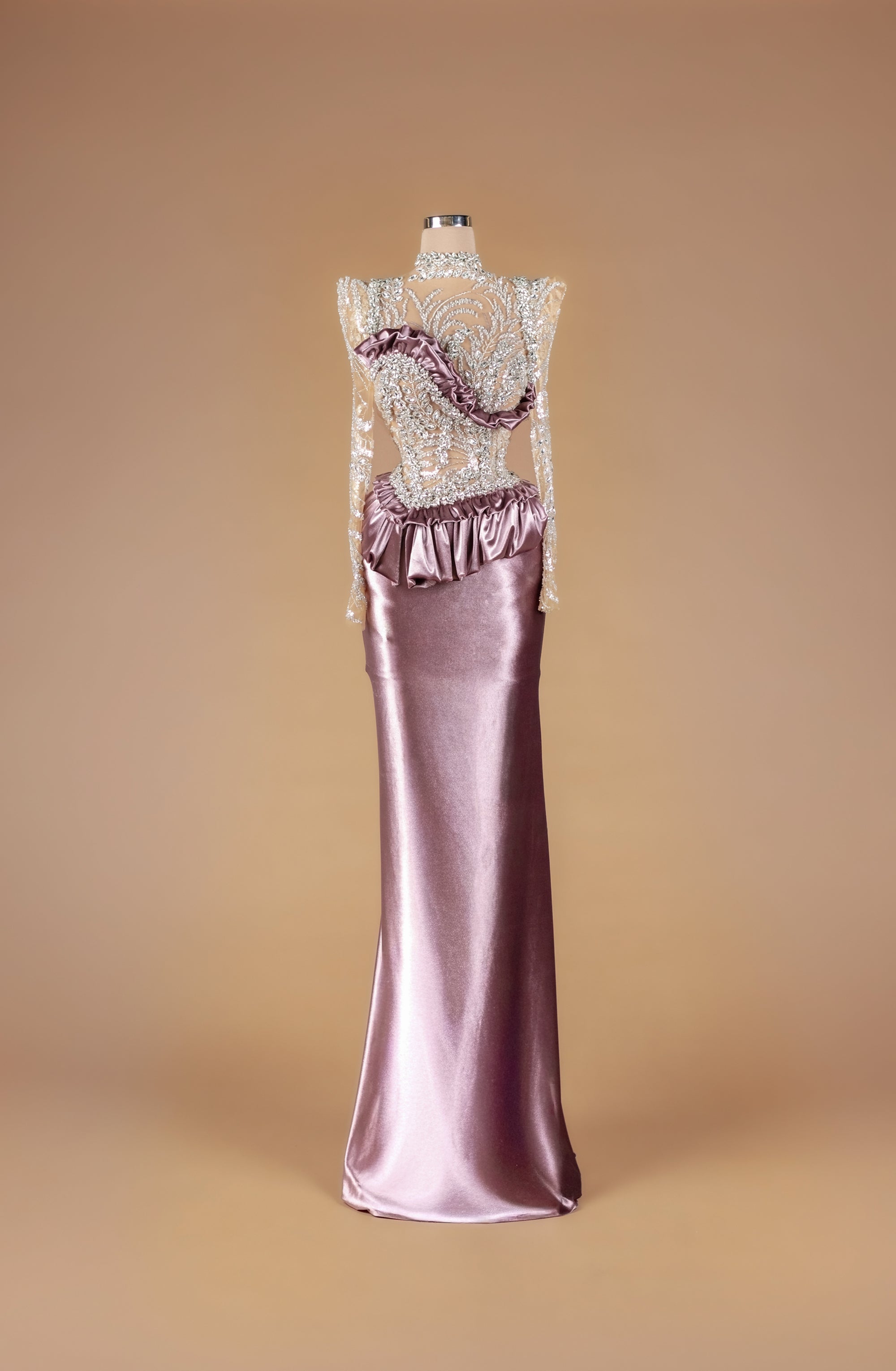 Sihëna Moonlit Mauve Reliquary — mauve high-neck long-sleeve column gown with crystal-beaded sheer illusion bodice and glossy satin ruffle skirt.