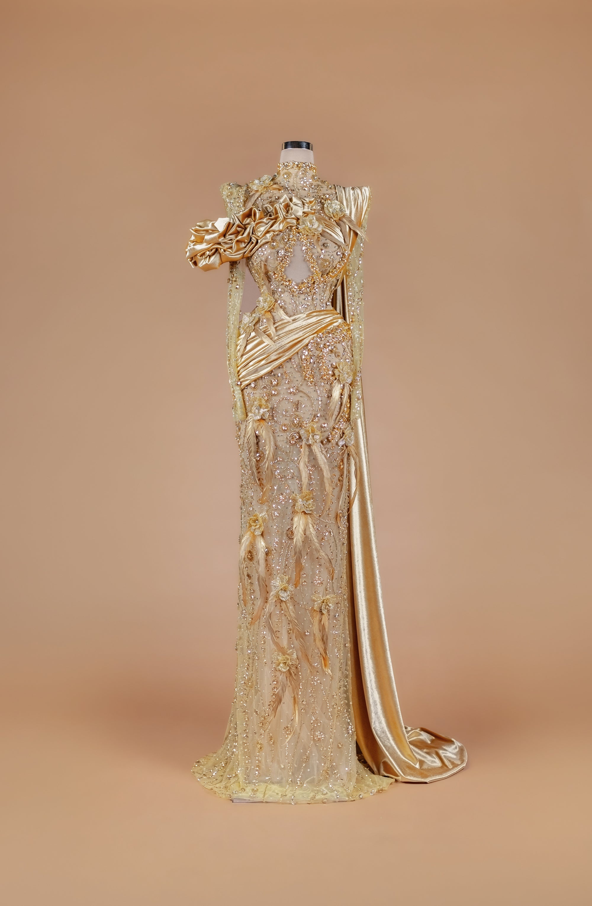 Sihëna Gilded Elysian Column — gold high-neck long-sleeve crystal-beaded illusion column gown with satin roses, feathers and gold floral embroidery.