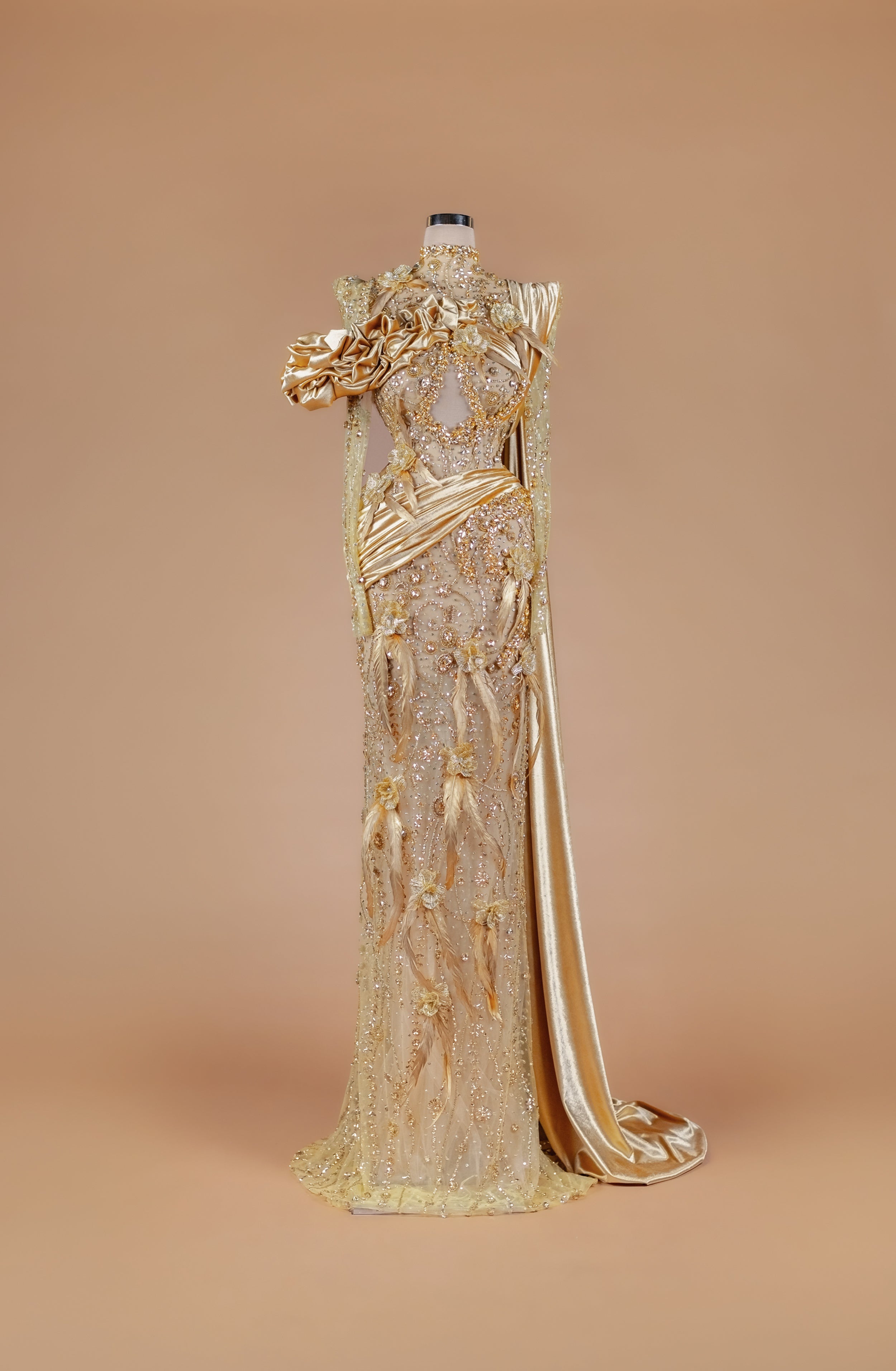 Sihëna Gilded Elysian Column — gold high-neck long-sleeve crystal-beaded illusion column gown with satin roses, feathers and gold floral embroidery.
