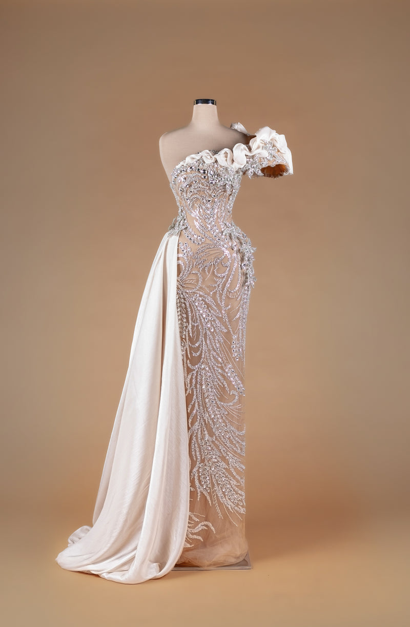 Sihëna Ivory Zephyr Arabesque — ivory one-shoulder crystal-beaded illusion column gown with organza ruffle shoulder and draped overskirt train.