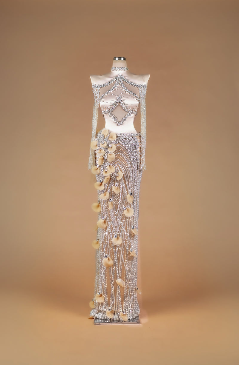 Sihëna Crystal Petal Tapestry — silver high-neck off-shoulder crystal-beaded illusion column gown with large midriff cutout and 3D organza petals.