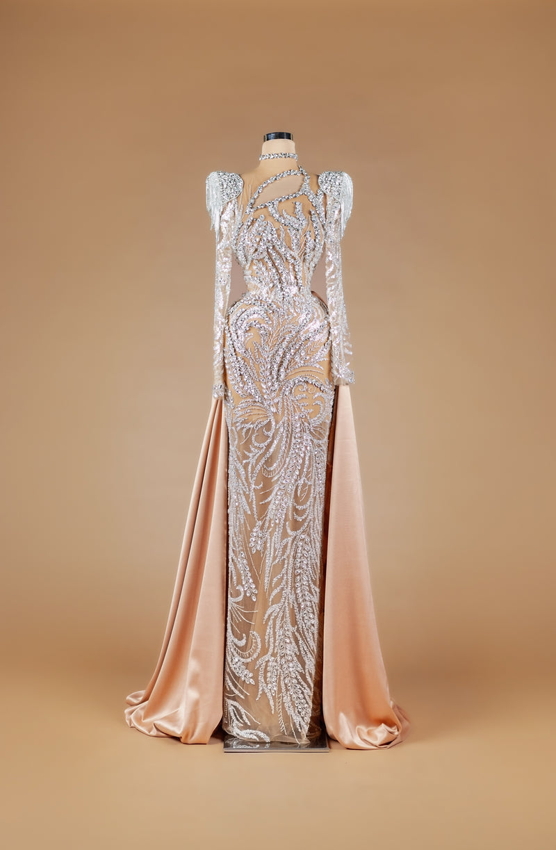 Sihëna Regal Frost Flourish — champagne high-neck long-sleeve crystal-beaded illusion column gown with structured shoulders and satin overskirt train.