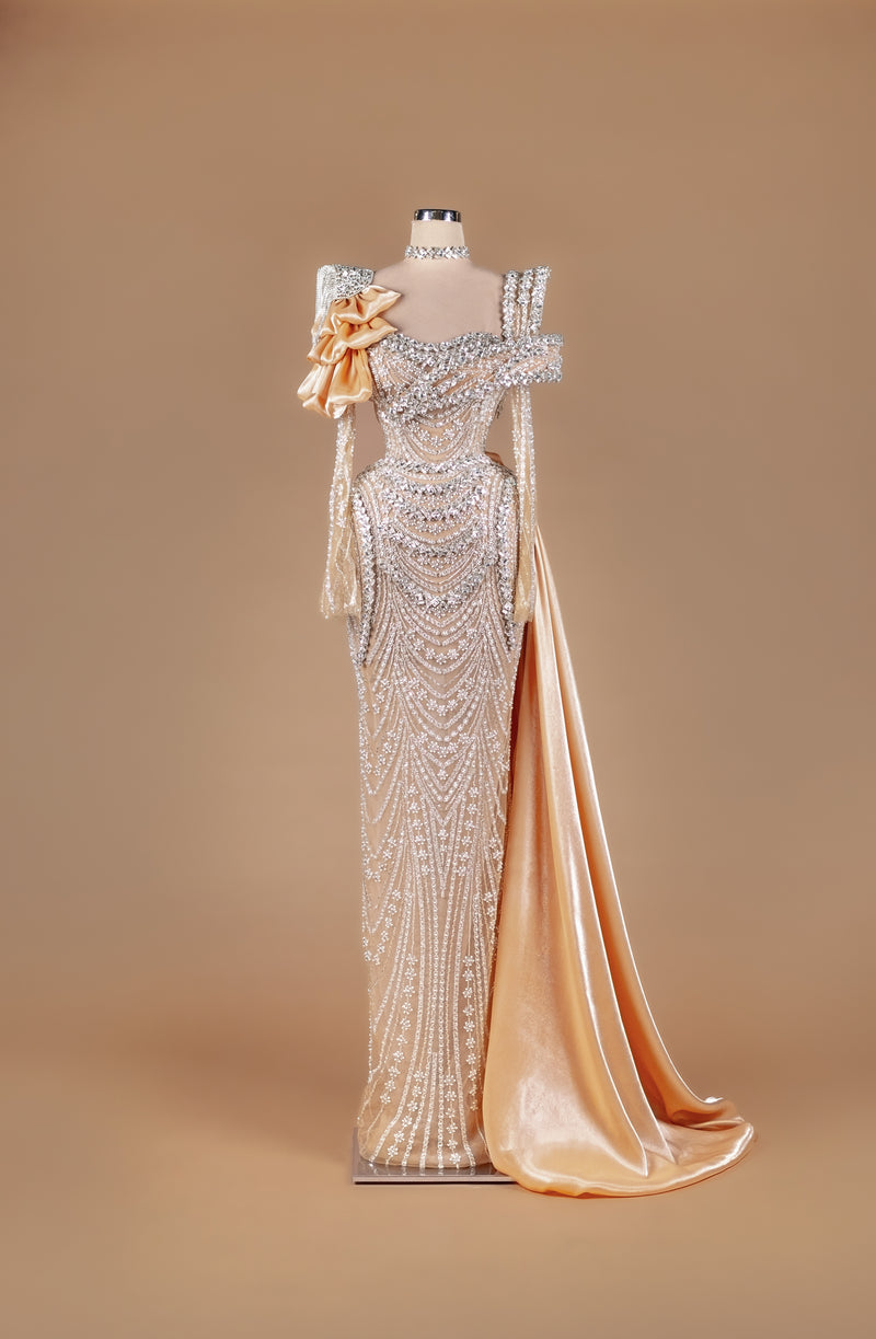 Sihëna Golden Minaret Gleam — gold high-neck off-shoulder pearl and crystal swag-beaded column gown with satin bow and draped overskirt train.