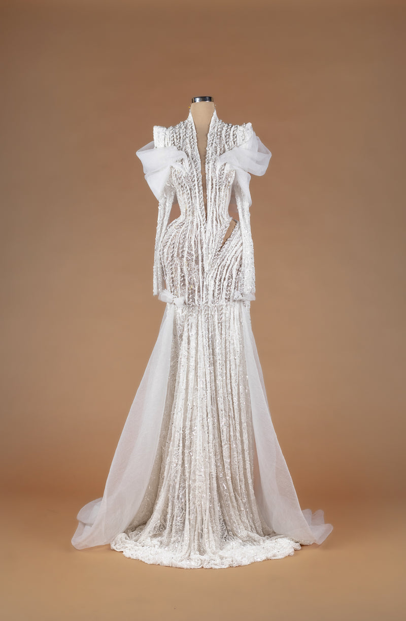 Sihëna Obsidian Whisper Drape — ivory deep-v long-sleeve beaded lace mermaid gown with structured shoulders, tulle overskirt train and side cutouts.