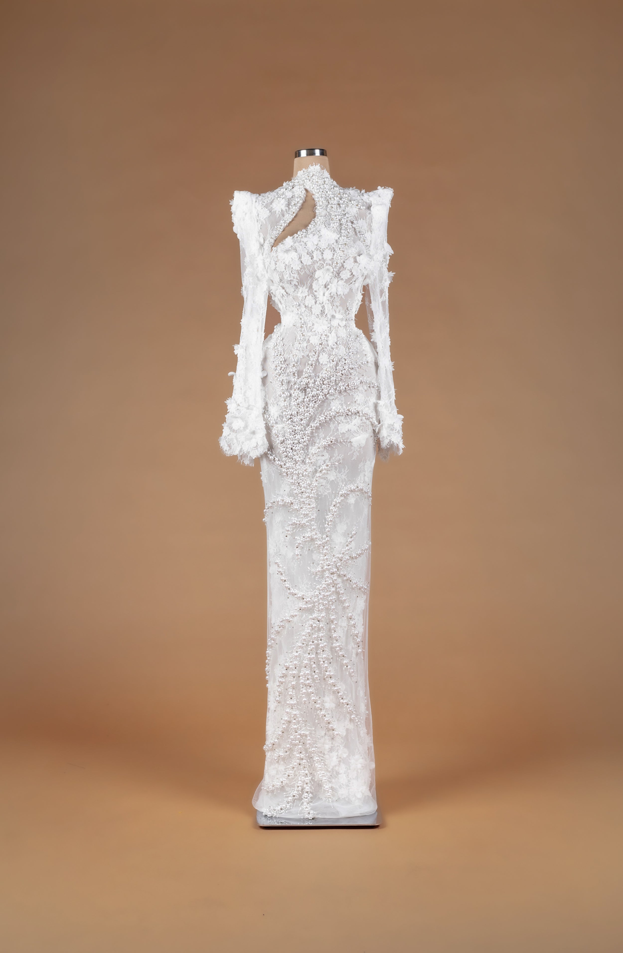 Sihëna Rosy Petal Tapestry — ivory high-neck long-sleeve lace column gown with 3D floral appliqué, cascading pearls and asymmetric keyhole cutout.
