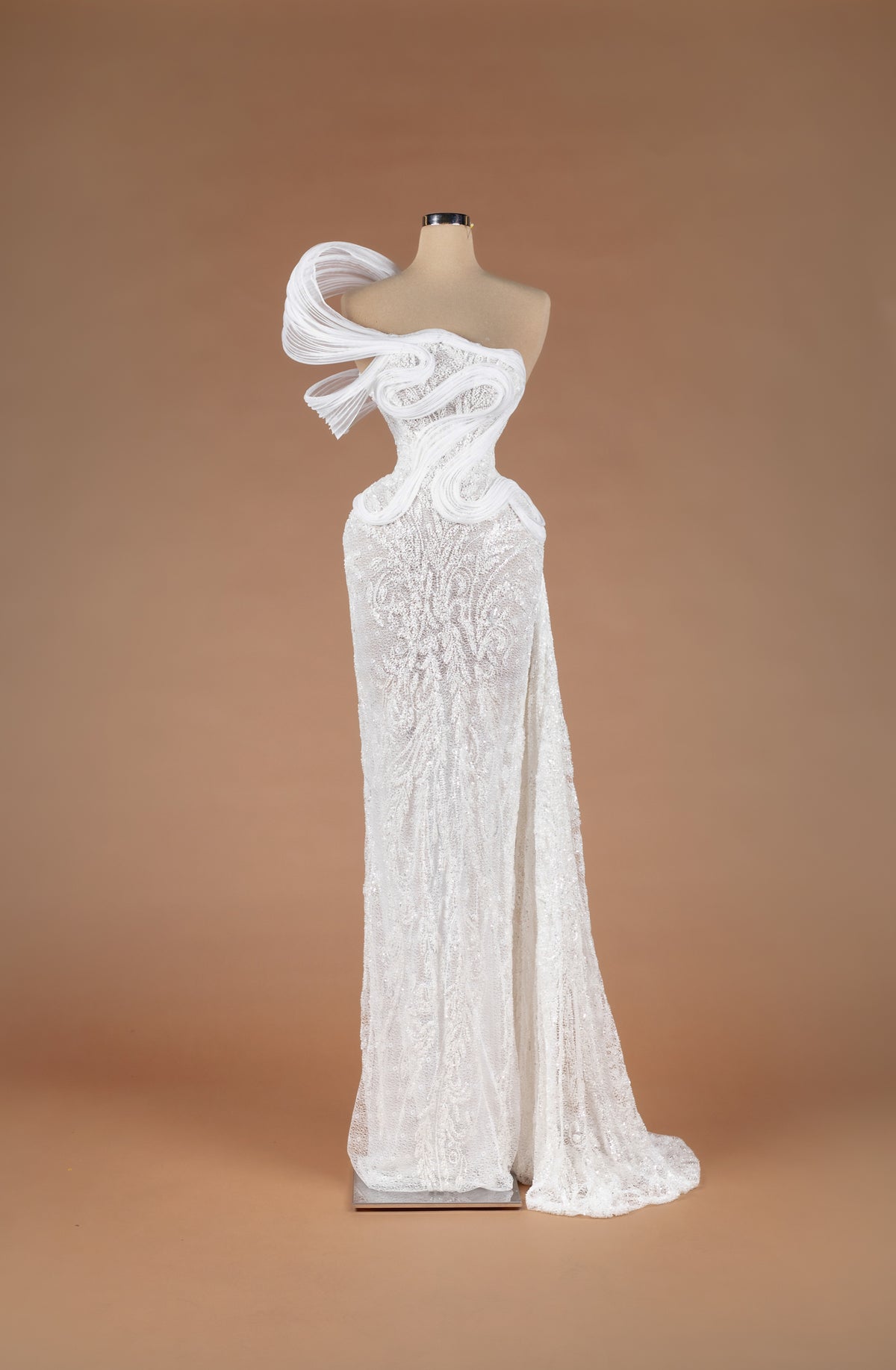 Sihëna Porcelain Serenity — ivory one-shoulder strapless beaded lace column gown with sculptural pleated organza swirls and side train.