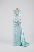 Sihëna Frosted Aurora Blossom — powder-blue high-neck long-sleeve gown with aqua organza florals and crystal beadwork on sheer tulle.